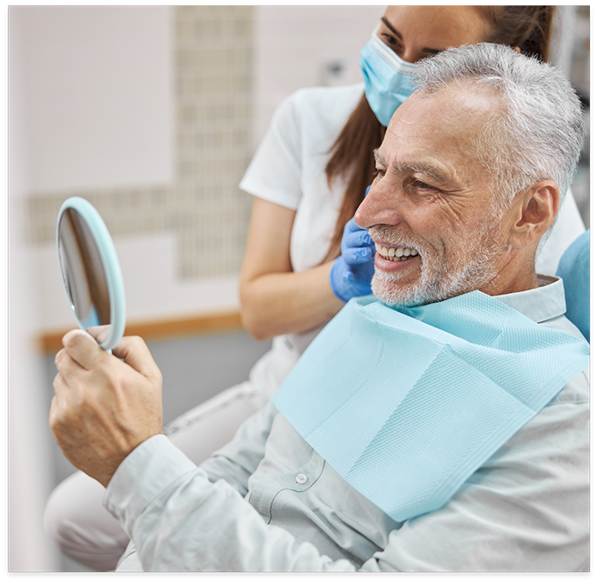 Senior man checking smile in mirror at dentists office