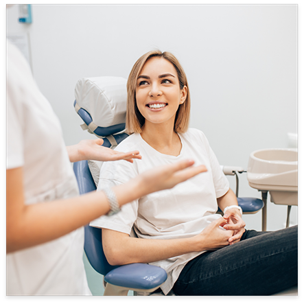 Woman in white shirt looking up at dentist