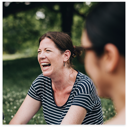 Woman in striped shirt laughing outside