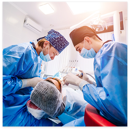 Two dentists treating a dental patient