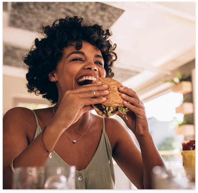 Woman at restaurant about to eat a burger