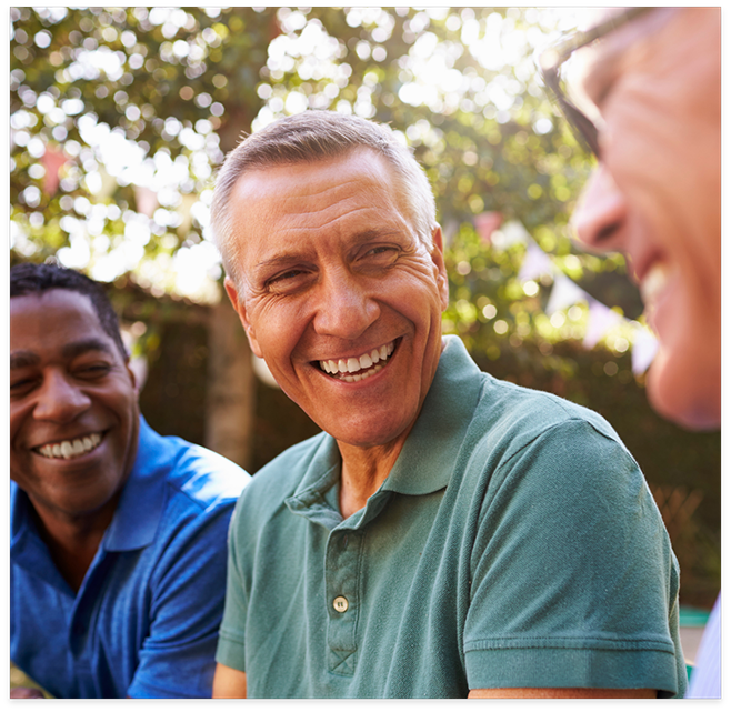 Men sitting outside and smiling at each other