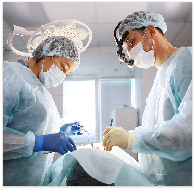 Dentists in surgical masks about to treat patient