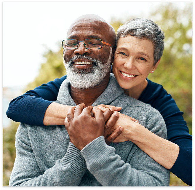 Senior man and woman hugging outside smiling