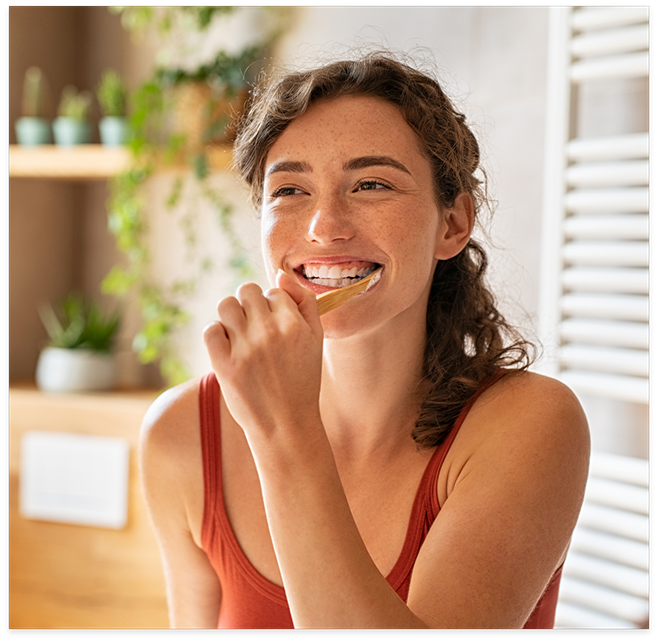 Woman in red shirt brushing her teeth