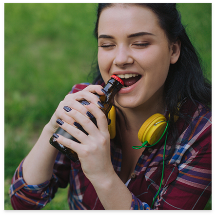 Woman with headphones biting on a package