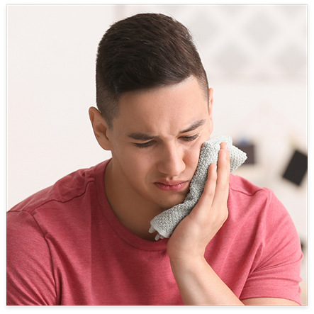 Man holding ice pack against jaw