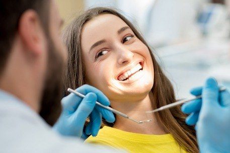 Dentist providing a periodic oral exam for a patient