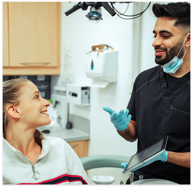 Woman talking to male dentist smiling