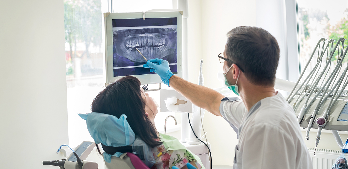 Dentist showing dental x ray to patient in chair