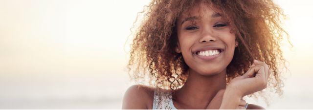 Close up of woman smiling with hand near face