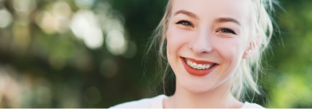 Woman with blonde hair smiling outside