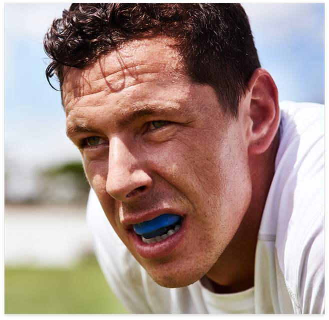 Man hunched over wearing a mouthguard