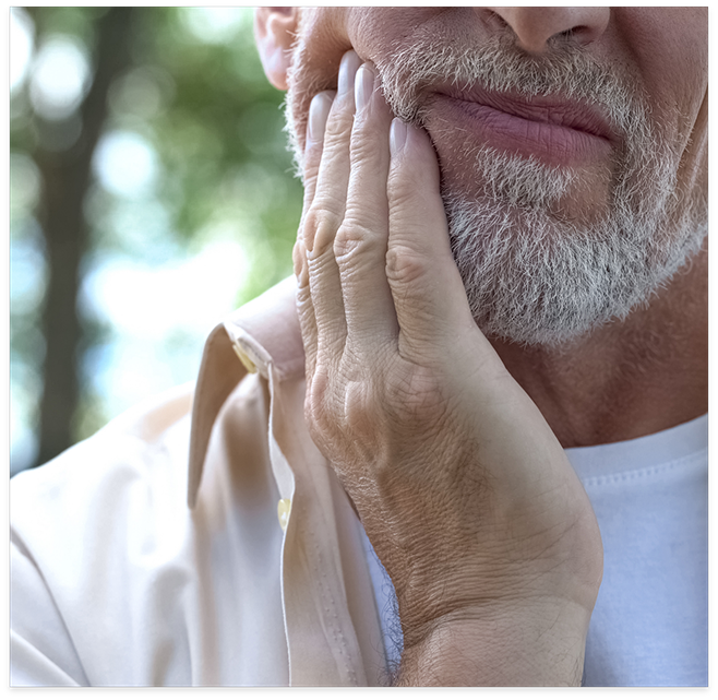 Close up of older man rubbing jaw in pain